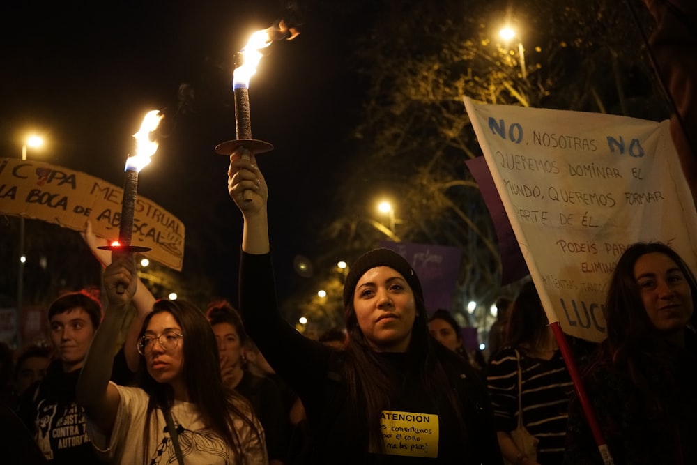 a group of people holding up signs and torches