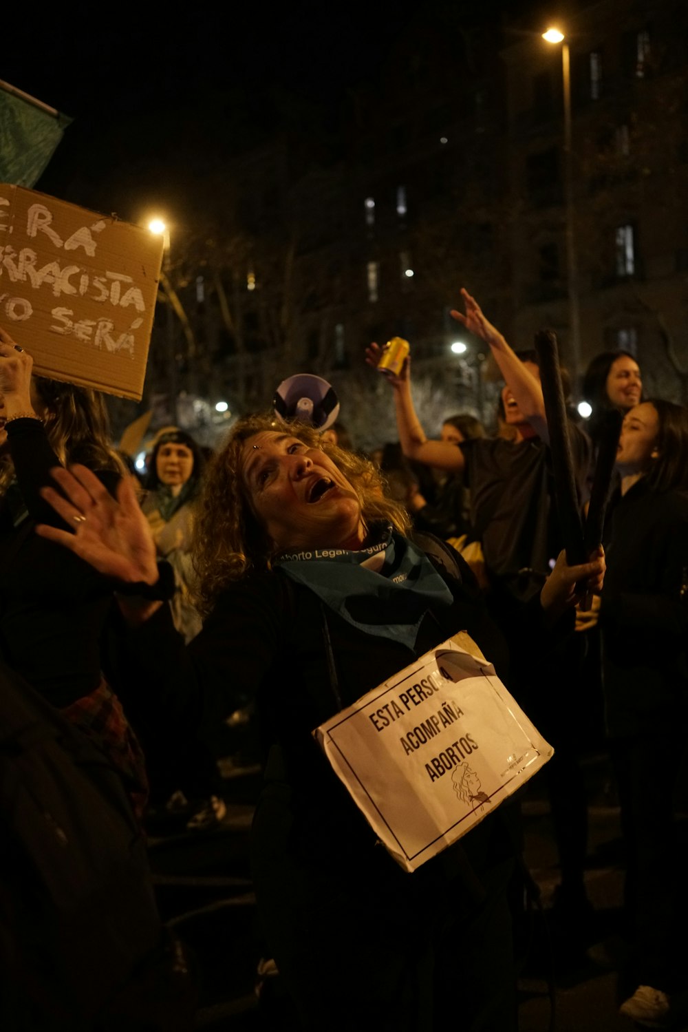 Un grupo de personas sosteniendo carteles por la noche