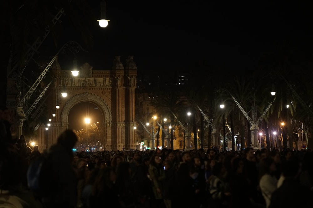 밤에 건물 앞에 서있는 사람들의 군중