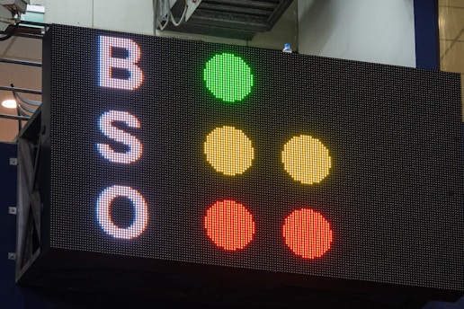 A large electronic scoreboard displays the letters 'B', 'S', and 'O' on the left side with corresponding colored dots to the right. The dots are arranged vertically in a traffic-light style, with green, yellow, and red illuminated next to each letter.