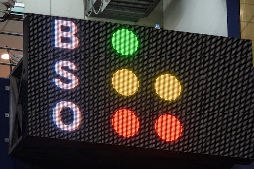 A large electronic scoreboard displays the letters 'B', 'S', and 'O' on the left side with corresponding colored dots to the right. The dots are arranged vertically in a traffic-light style, with green, yellow, and red illuminated next to each letter.