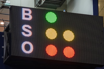 A large electronic scoreboard displays the letters 'B', 'S', and 'O' on the left side with corresponding colored dots to the right. The dots are arranged vertically in a traffic-light style, with green, yellow, and red illuminated next to each letter.