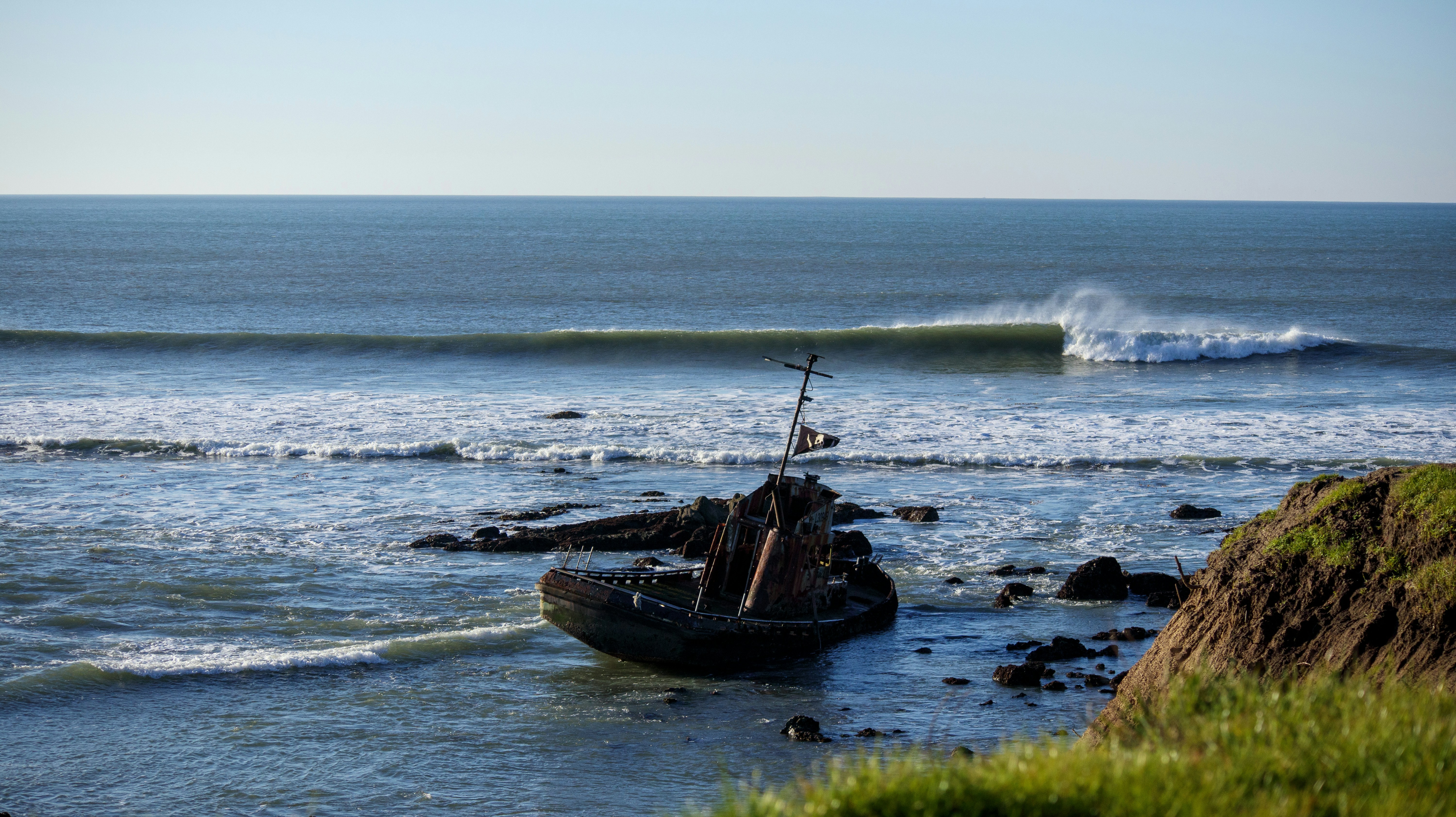 a boat sitting on top of a beach next to the ocean