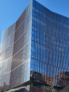 A sleek commercial office building with reflective glass windows under a clear sky