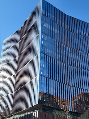 Modern office building with clean lines and large glass windows representing real estate business.