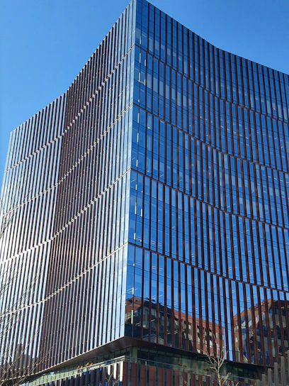 Modern office building facade with clean lines and large windows under a clear sky
