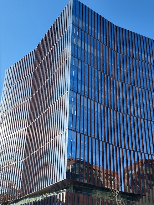 A sleek commercial office building with reflective glass windows under a clear sky