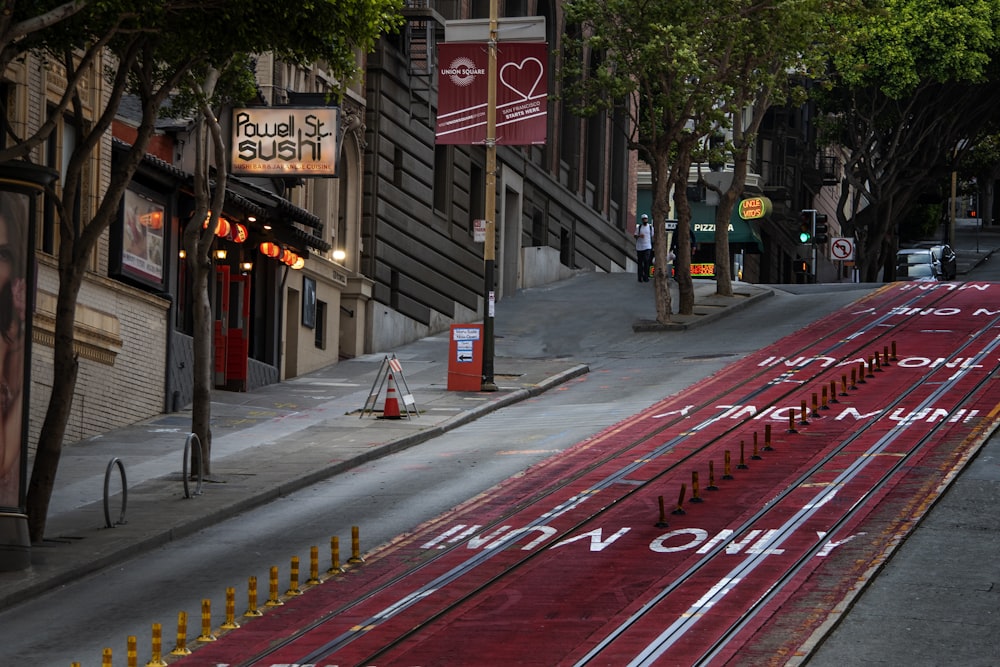 a train track on a city street with buildings in the background