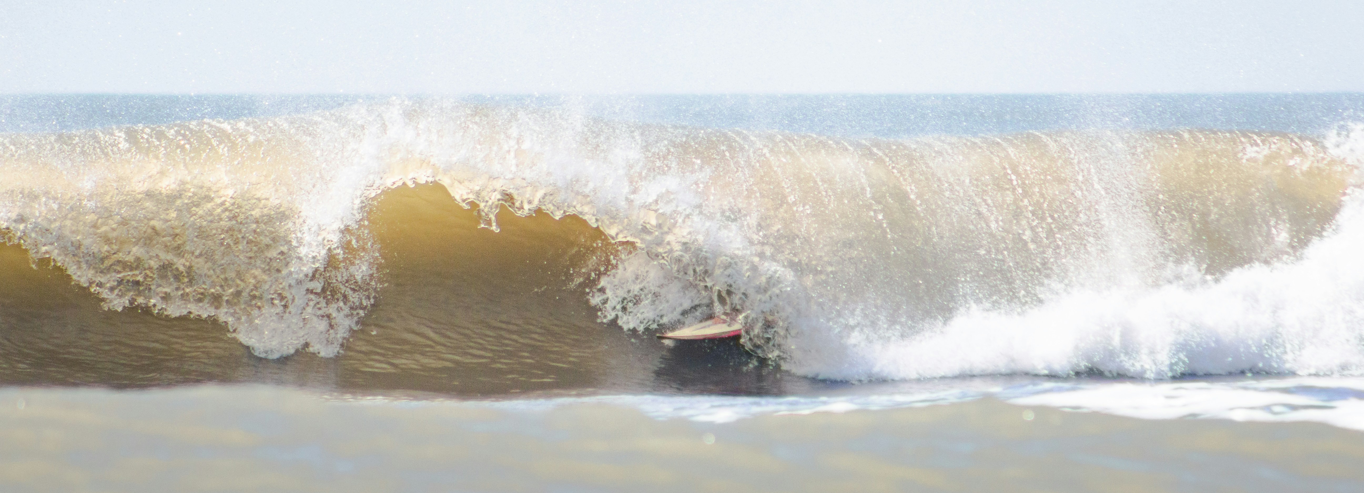 a man riding a wave on top of a surfboard (Photo by Social Foto Club on Unsplash)
