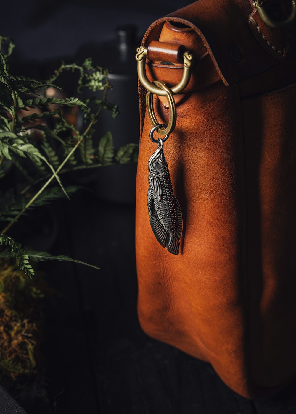 Una borsa in pelle marrone con un ciondolo di piume appeso ad essa foto –  Borsa Immagine gratuita su Unsplash