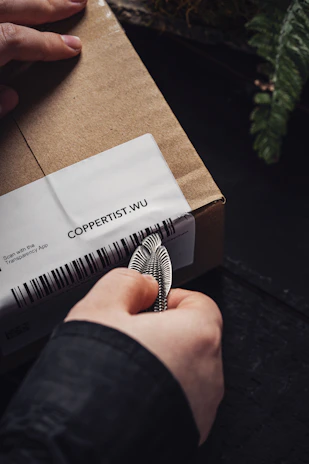 Close-up of a courier scanning a package with a handheld device, showing precision.