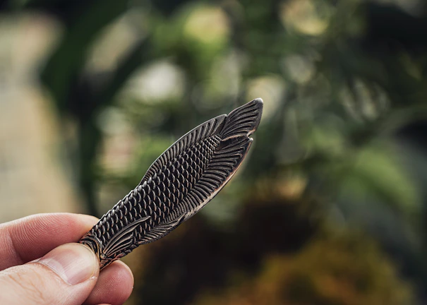 Artistic shot of a hand holding a small, stylish 3D printed hiking trail souvenir.