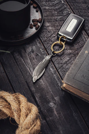 Close-up of car keys resting on a map with a coffee cup nearby, ready for a journey.