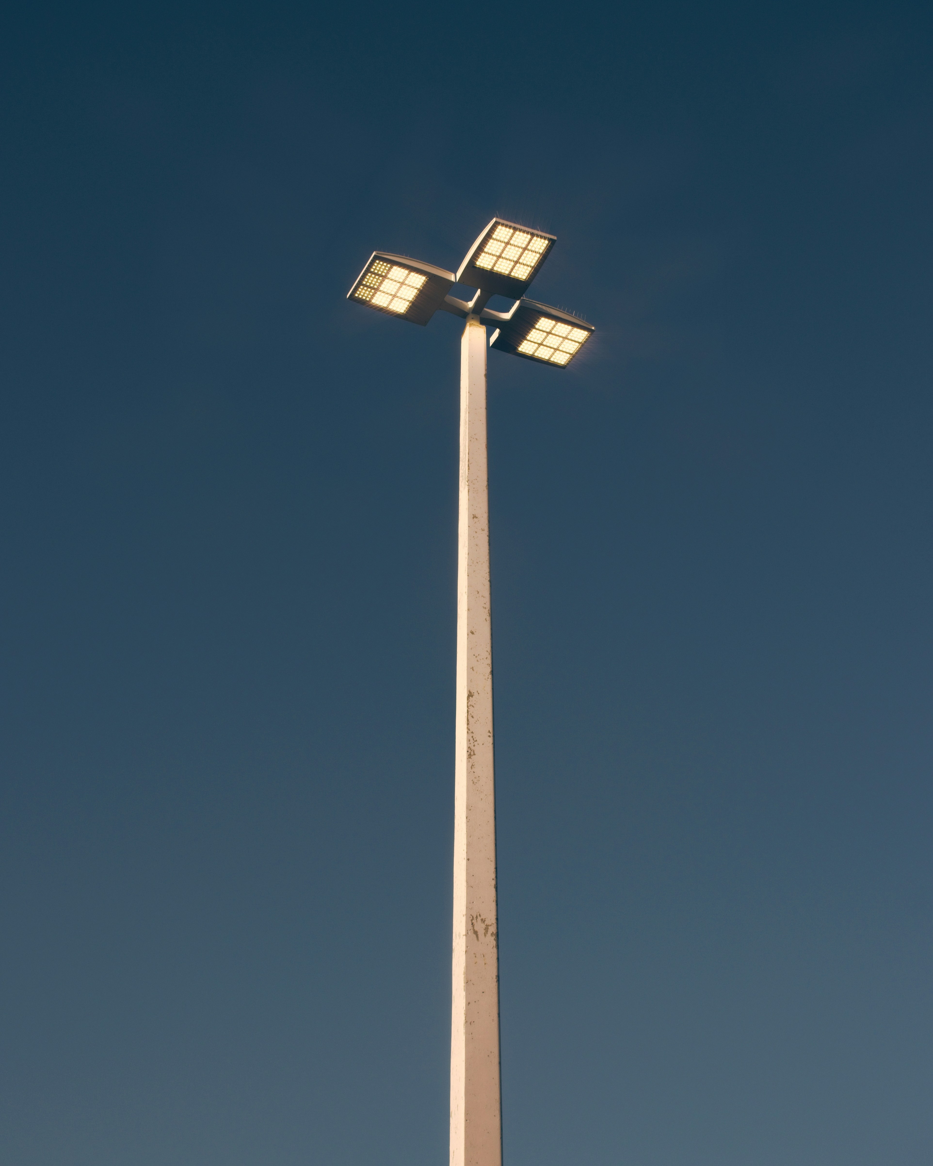 un poste de luz alto con tres luces encima.