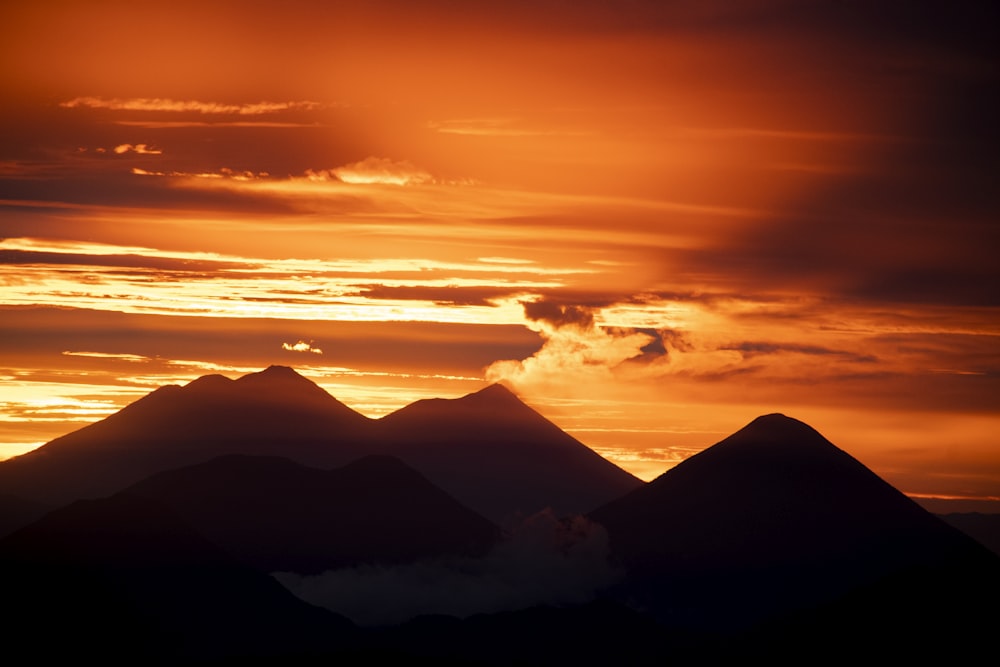 the sun is setting behind a mountain range