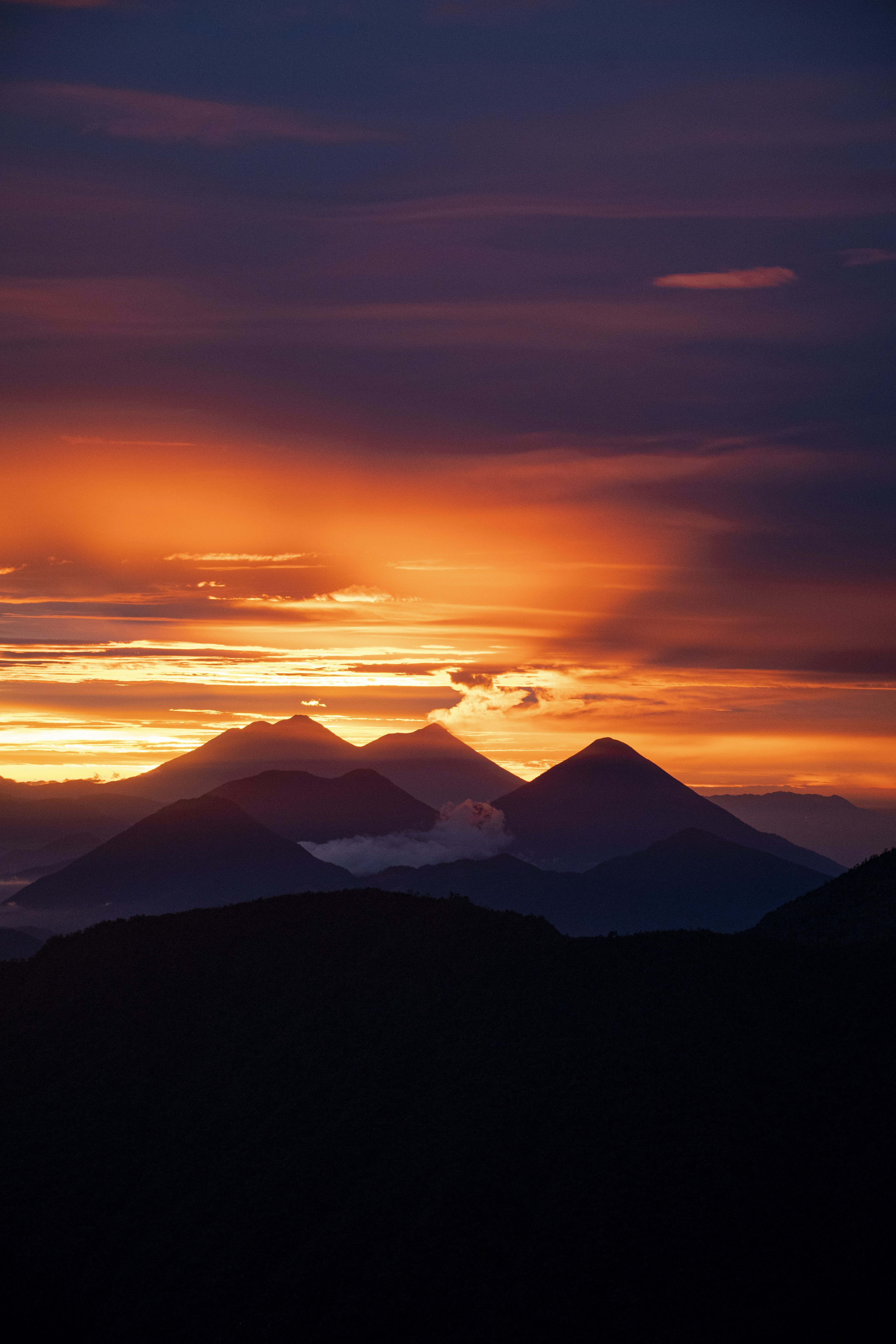 the sun is setting over a mountain range