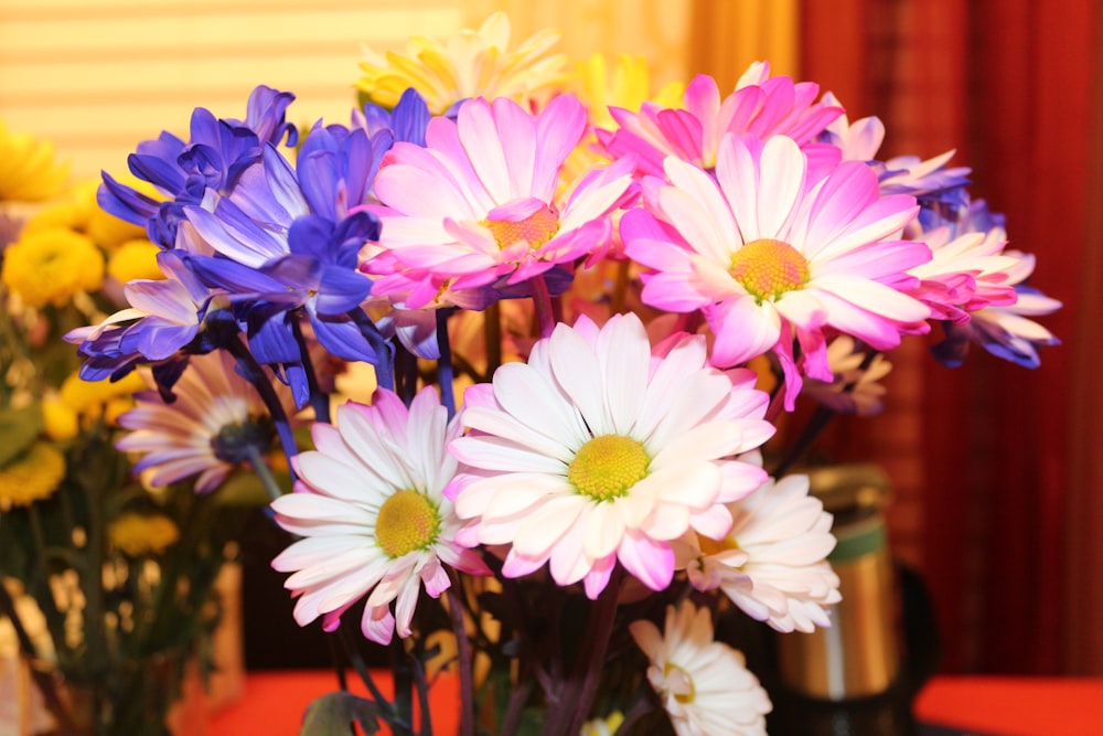 a vase filled with purple, white and yellow flowers