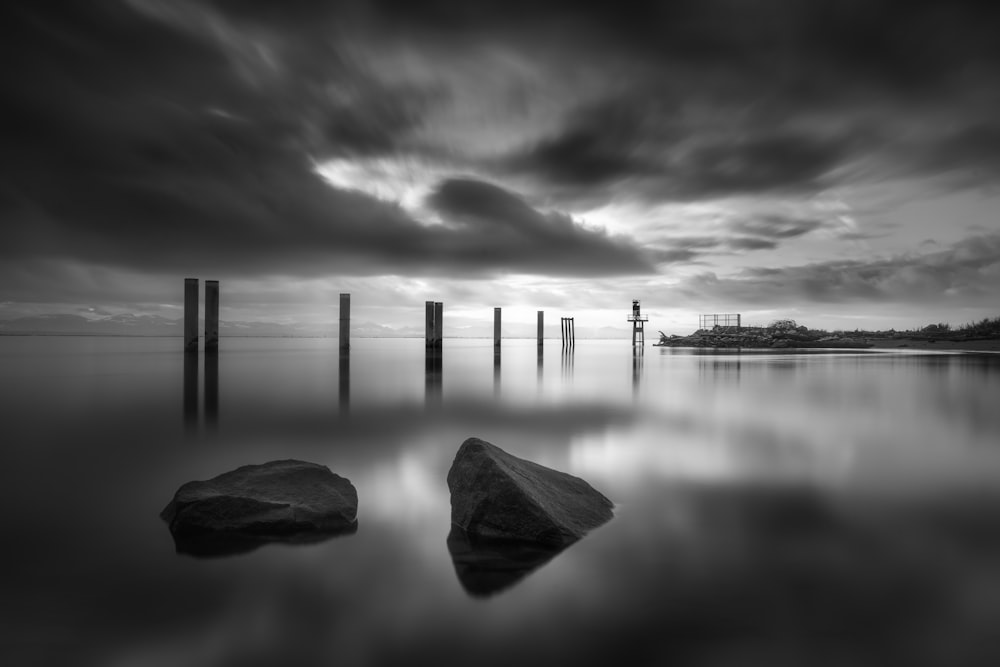 a black and white photo of some rocks in the water