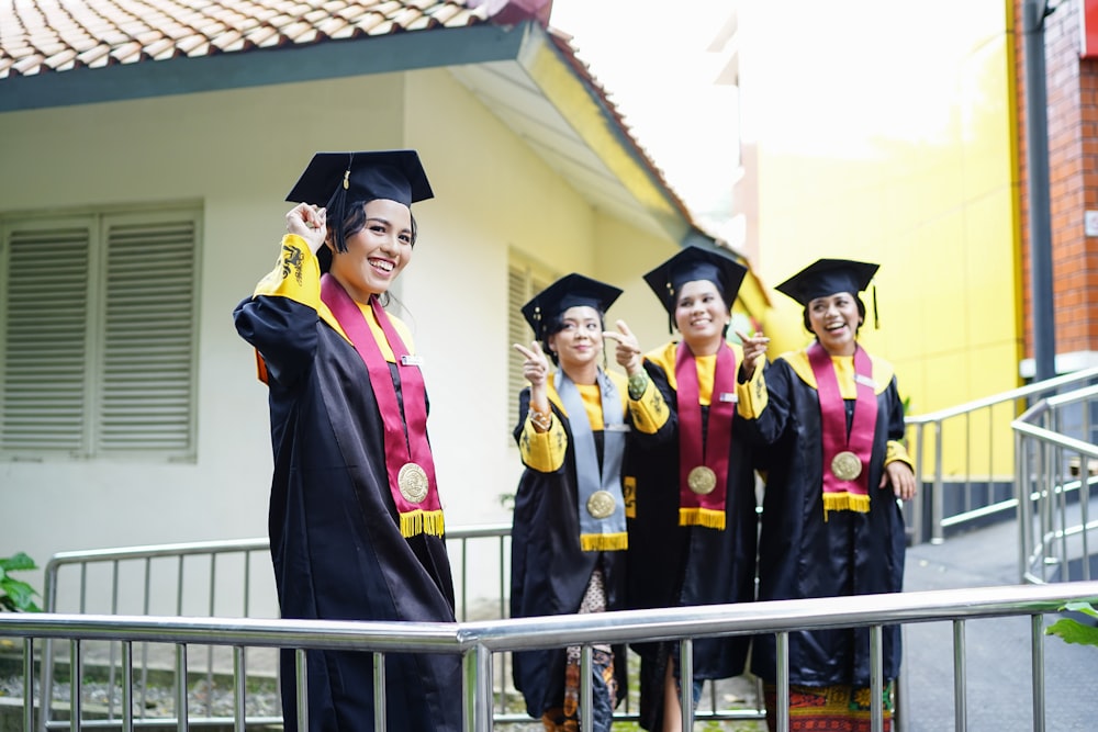 a group of women in graduation gowns standing next to each other