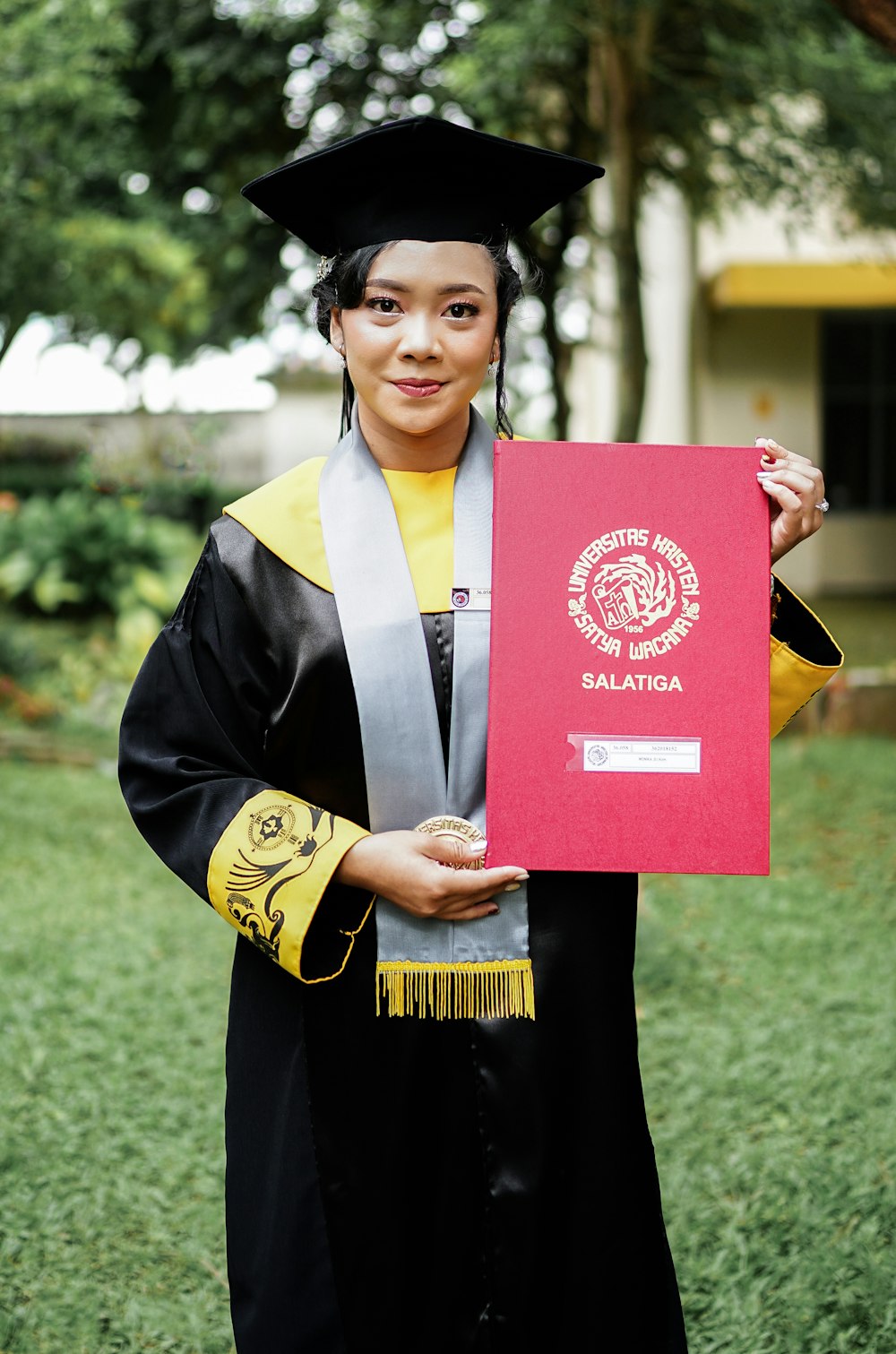 a woman in a graduation gown holding a diploma