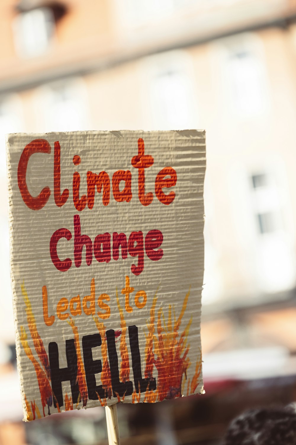 a protest sign that reads climate change leads to hell