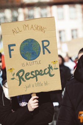 a woman holding a sign that says all i'm asking for is a little