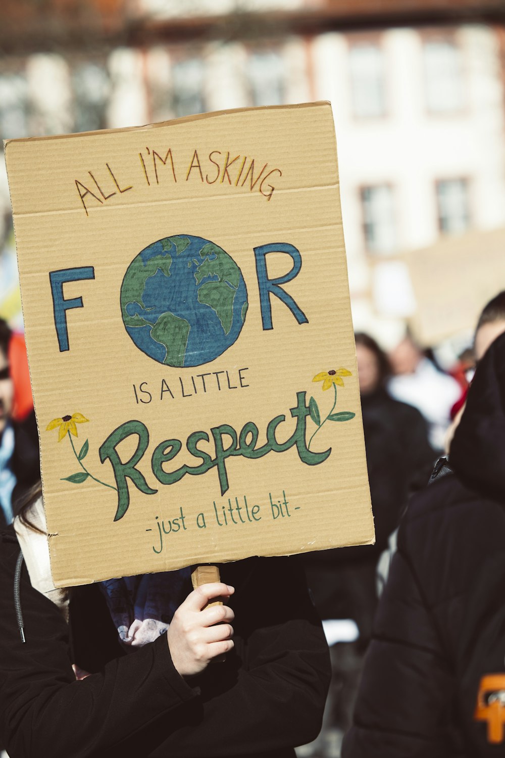 a woman holding a sign that says all i'm asking for is a little