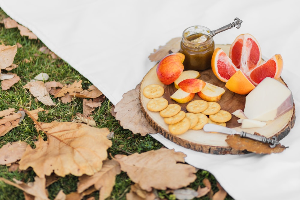 a plate of cheese, crackers, and fruit on a table