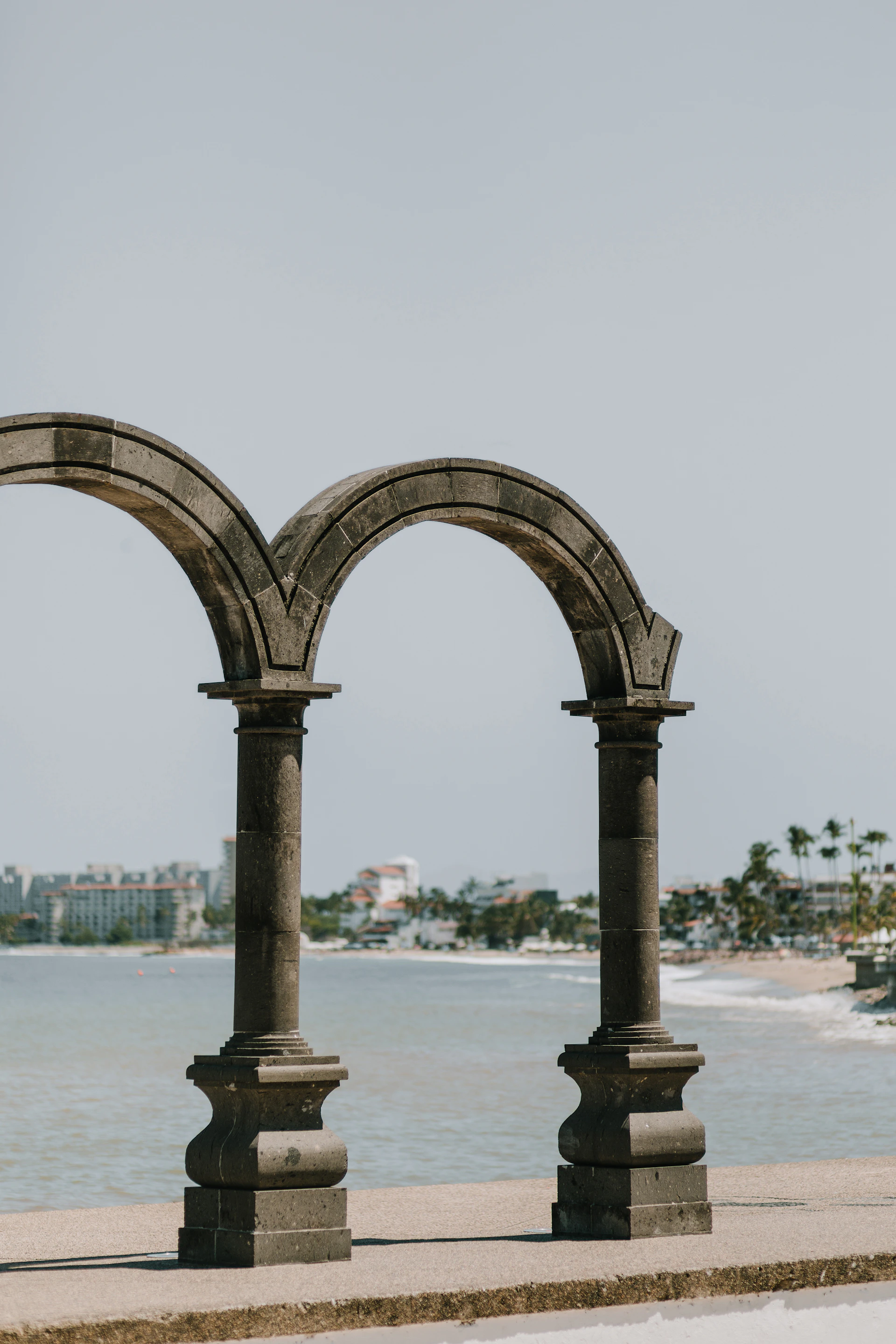 a couple of stone arches sitting next to a body of water