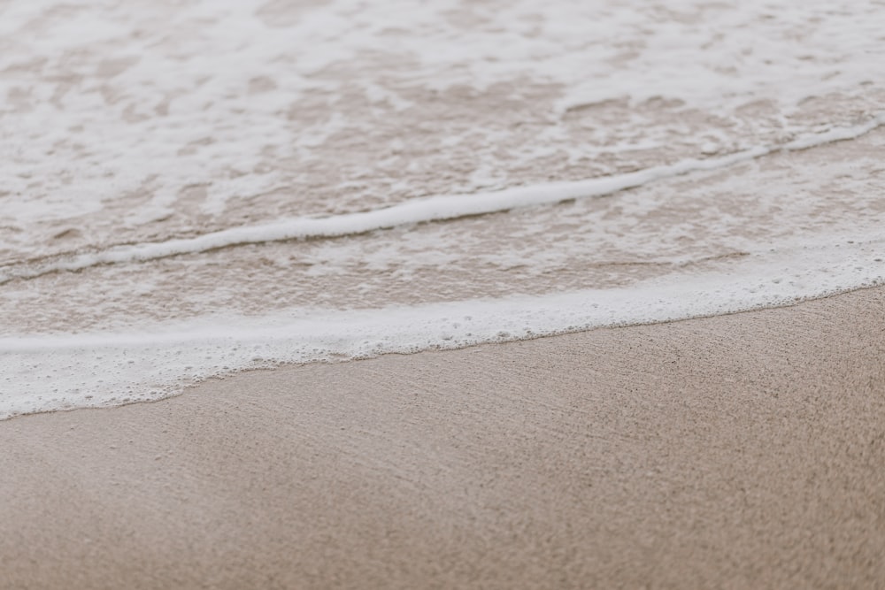 a close up of the sand and water of a beach