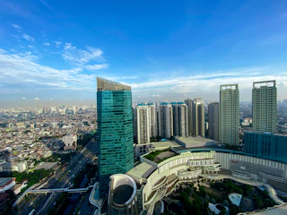 A panoramic view of a sleek, modern urban development showcasing mixed-use buildings with elegant architectural lines under a clear sky.