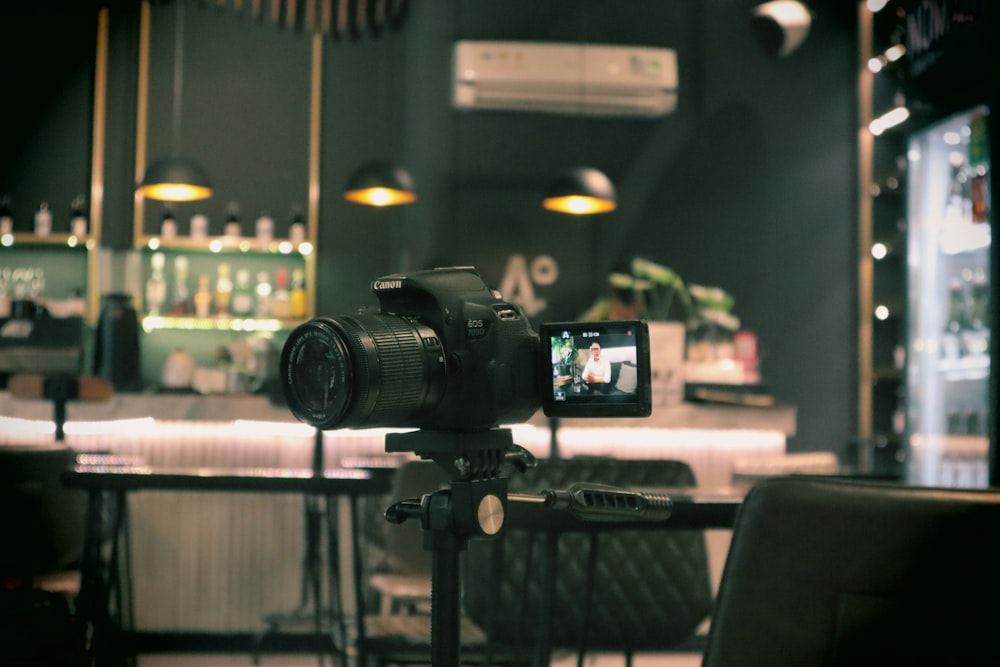 una macchina fotografica seduta sopra un treppiede di fronte a un bar