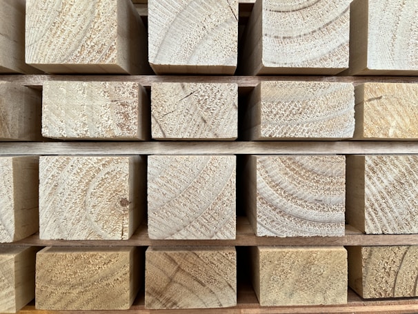 A set of wooden beams neatly stacked, ready for construction use.