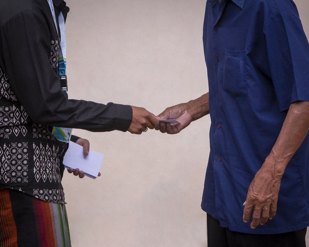 a man handing another man a piece of paper