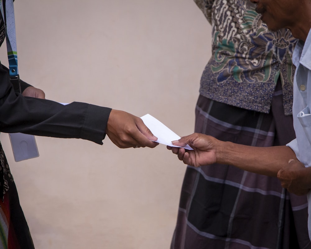 a person handing another person a piece of paper