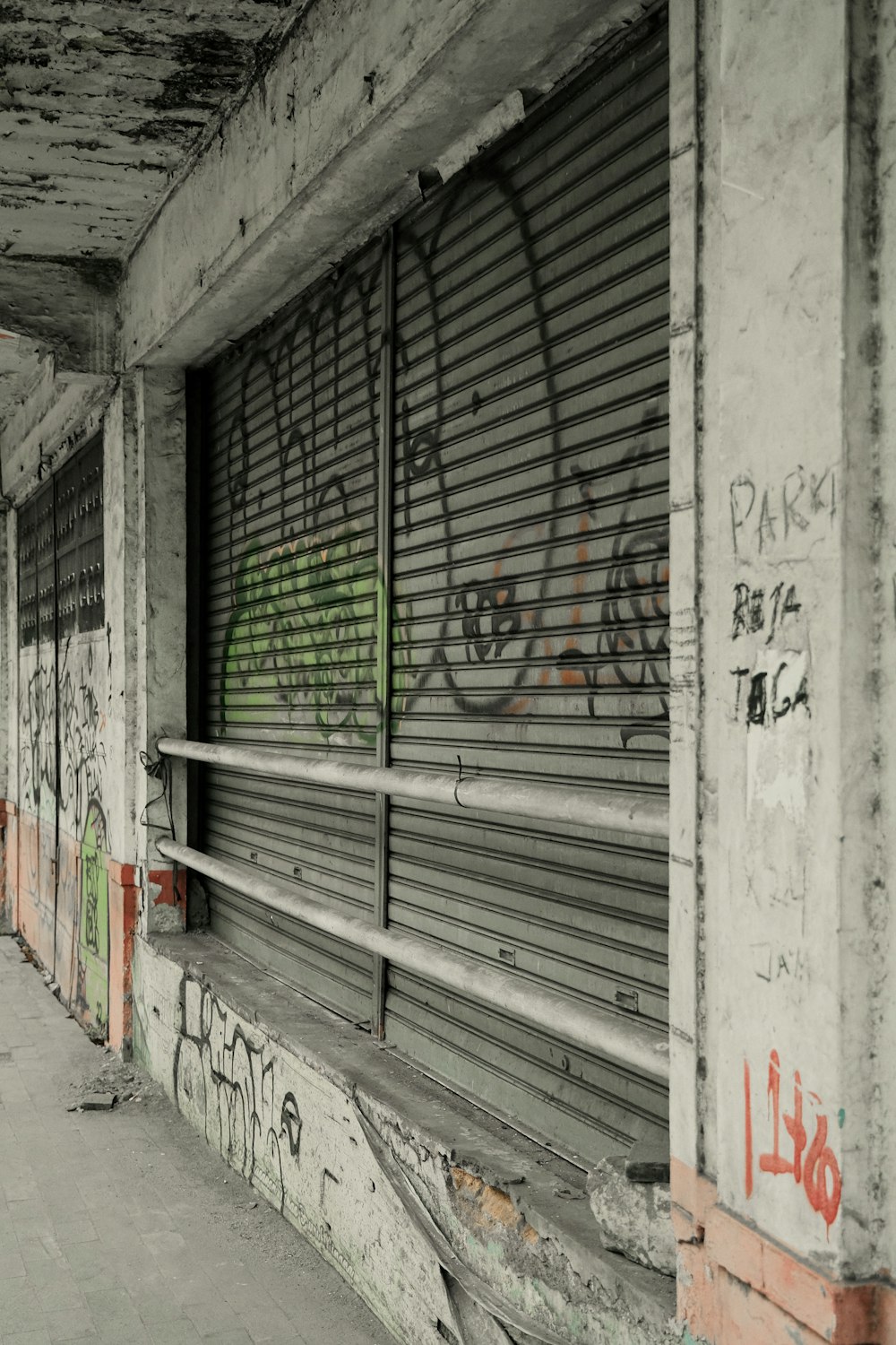 a man riding a skateboard down a street next to graffiti