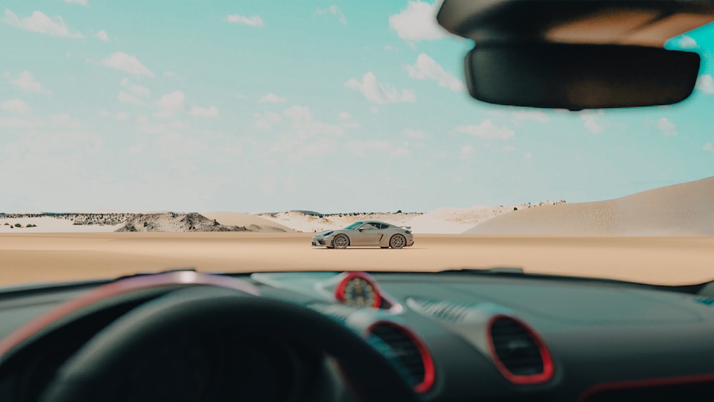 Un coche conduciendo por una carretera desértica con un cielo de fondo