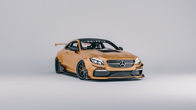 A sleek, modern sports car with a striking gold finish and aerodynamic design. The vehicle features a prominent front grille, sporty alloy wheels, and a rear spoiler for enhanced performance aesthetics.