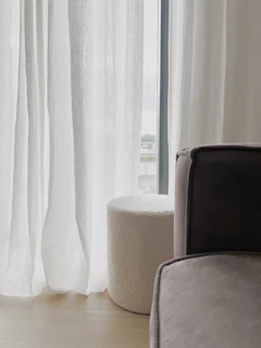 Soft bedroom scene featuring rounded white furniture and green textiles