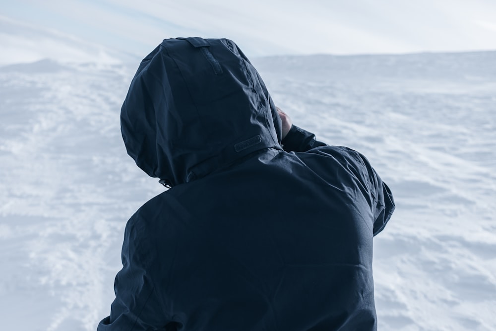 a person standing in the snow with their back to the camera