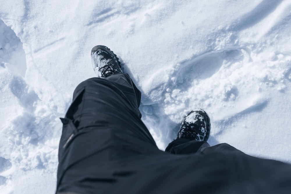a person standing in the snow with their feet in the snow