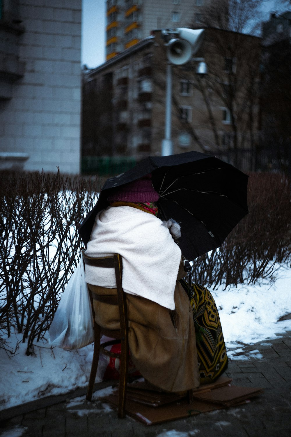 a person sitting in a chair with an umbrella