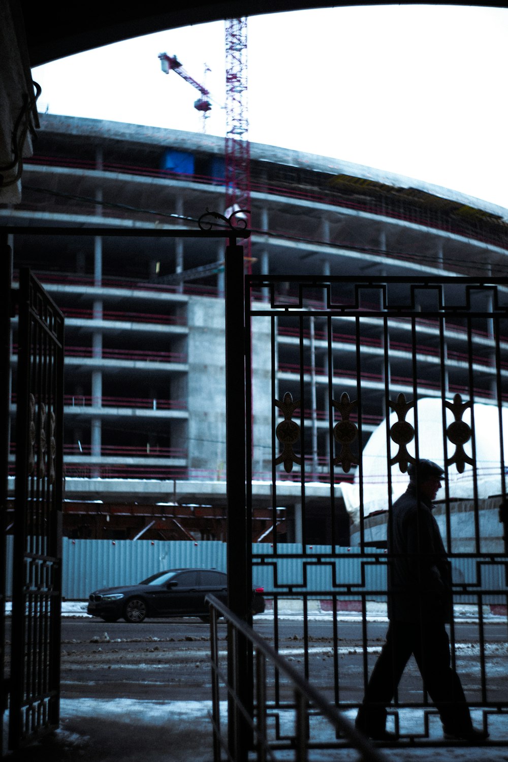 a man walking down a street past a tall building