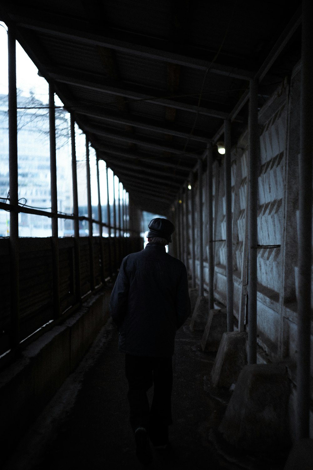 a person walking down a walkway in the dark