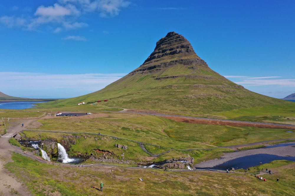 a large mountain with a small waterfall in the middle of it