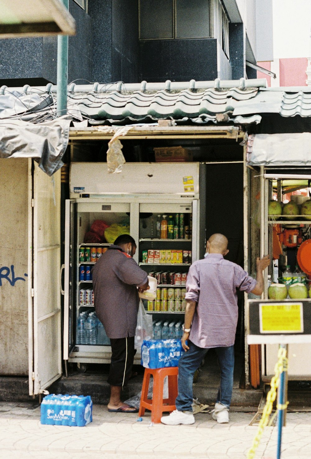 a couple of men standing outside of a store