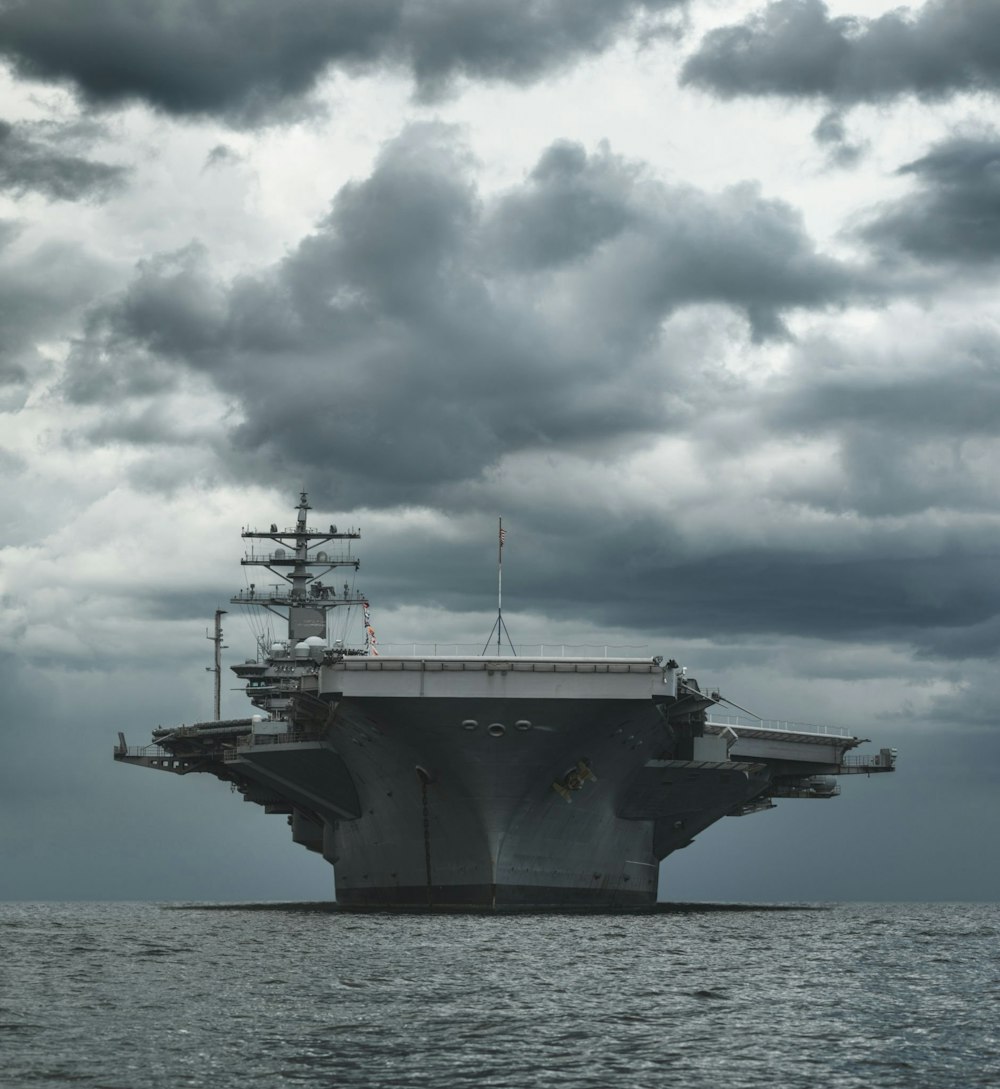 a large aircraft carrier floating on top of a body of water