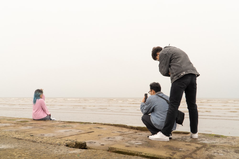 a man taking a picture of a woman on the beach