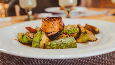 Close-up of a succulent grilled salmon plated with fresh herbs and lemon slices at Riverside restaurant