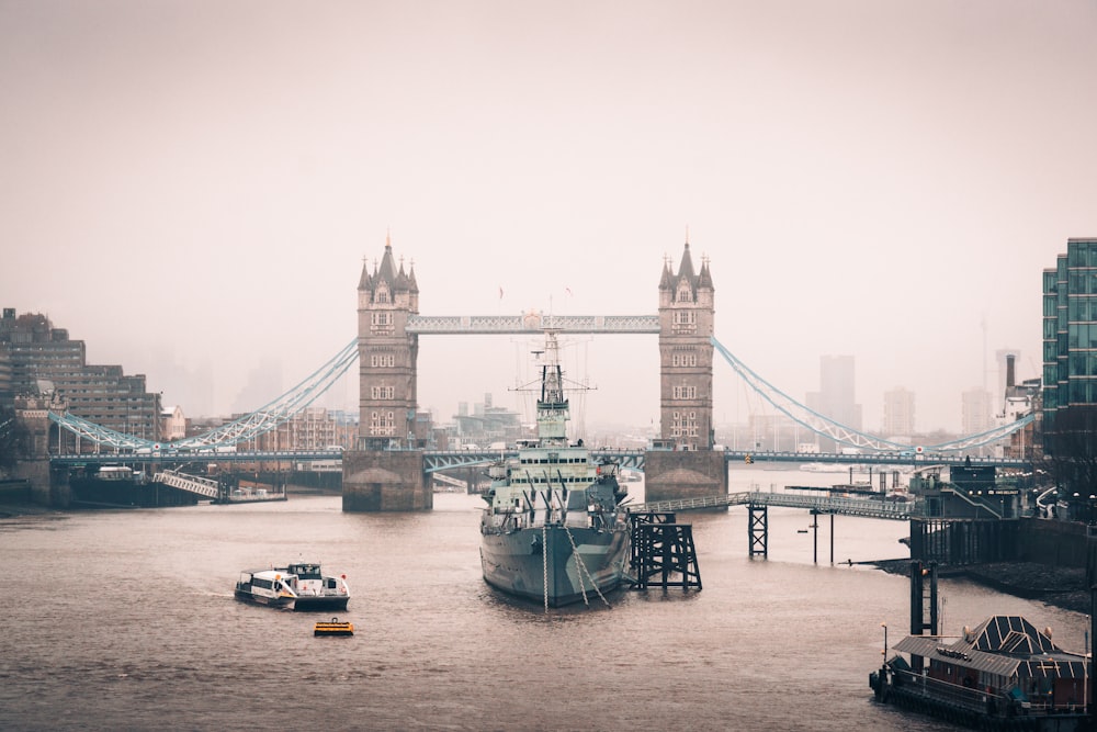 a boat in the water in front of a bridge